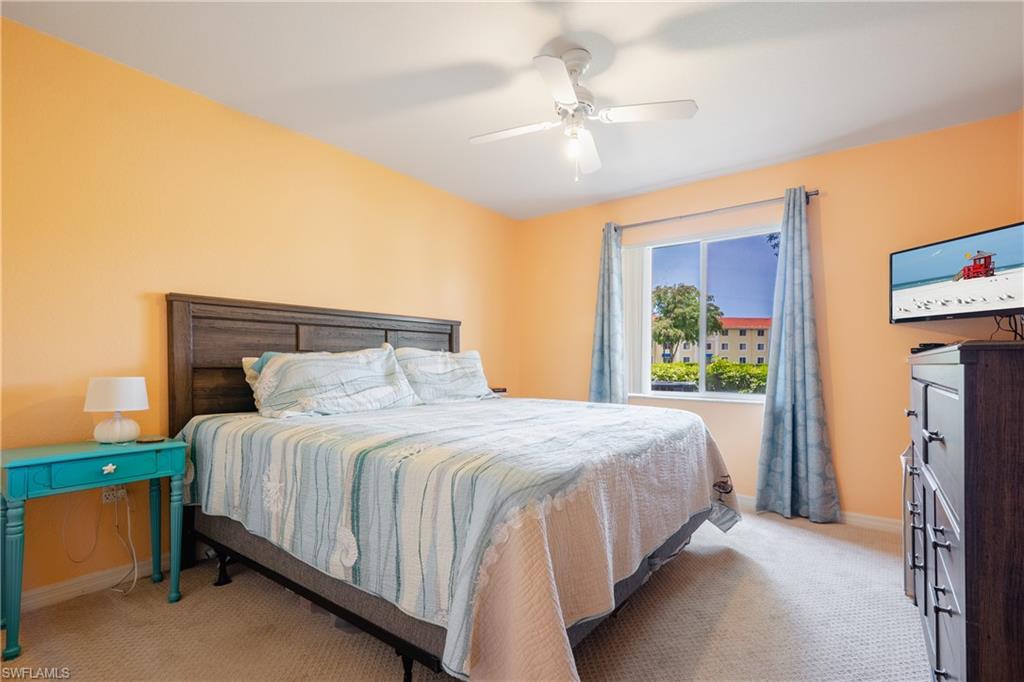 8264 Key Royal Circle, Unit 813 Naples, FL 34119 - Photo 12 of 21 a bedroom with a bed and a chandelier