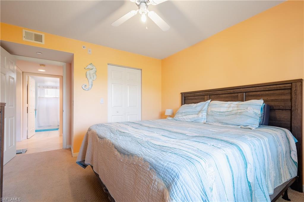 8264 Key Royal Circle, Unit 813 Naples, FL 34119 - Photo 13 of 21 a bedroom with a bed and a chandelier