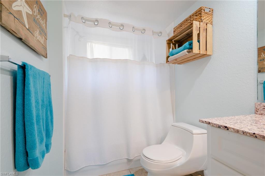 8264 Key Royal Circle, Unit 813 Naples, FL 34119 - Photo 14 of 21 a white toilet sitting next to a bathroom sink