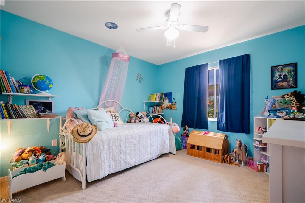 8264 Key Royal Circle, Unit 813 Naples, FL 34119 - Photo 16 of 21 a bedroom with a bed and a chandelier