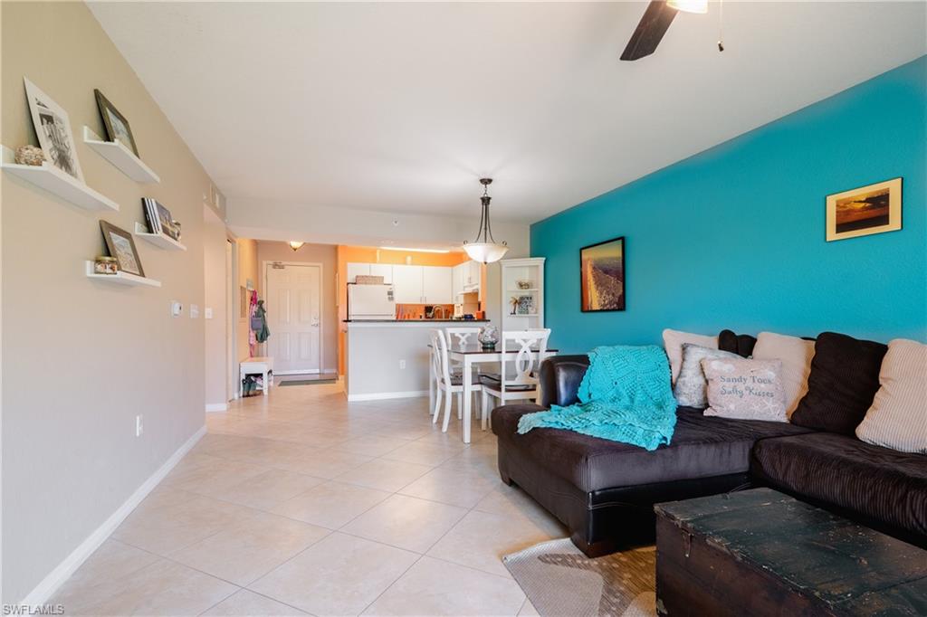 8264 Key Royal Circle, Unit 813 Naples, FL 34119 - Photo 20 of 21 a living room with furniture and a chandelier