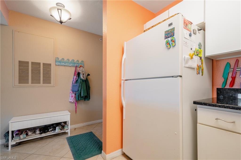 8264 Key Royal Circle, Unit 813 Naples, FL 34119 - Photo 9 of 21 a white refrigerator freezer and a stove sitting inside of a kitchen