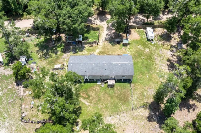 a aerial view of a house with swimming pool and large trees