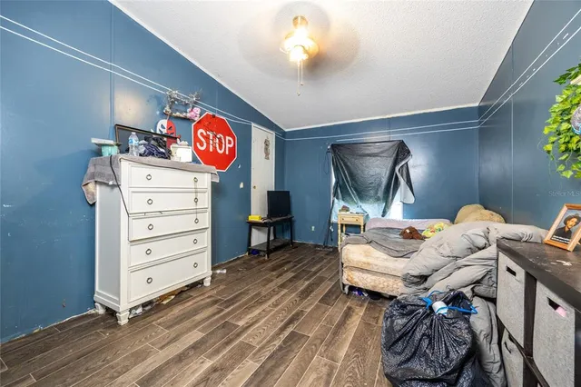 a bedroom with a bed and a flat tv screen on dresser