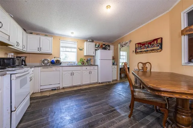 a kitchen with cabinets appliances a sink and a window