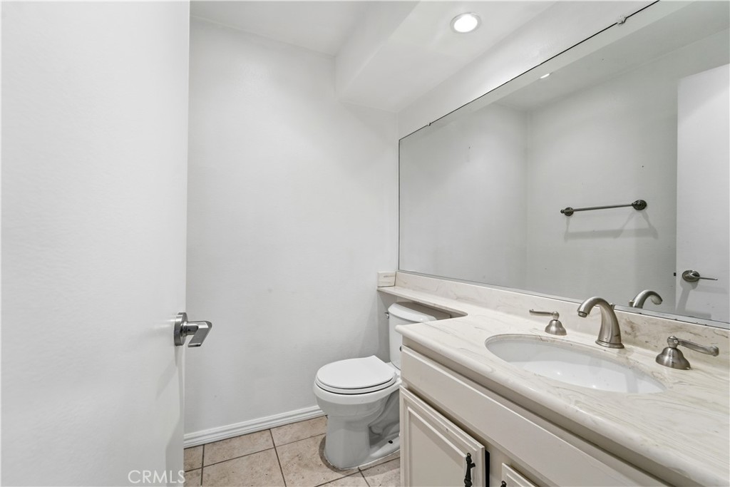 16650 Rinaldi Street Granada Hills, CA 91344 - Photo 17 of 35 a bathroom with a granite countertop sink toilet a mirror and shower