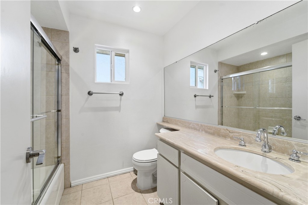 16650 Rinaldi Street Granada Hills, CA 91344 - Photo 22 of 35 a bathroom with a granite countertop sink a toilet and shower