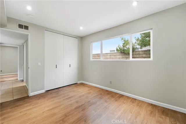 a view of empty room with wooden floor