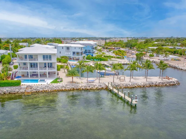 a front view of a house with plants and wooden fence