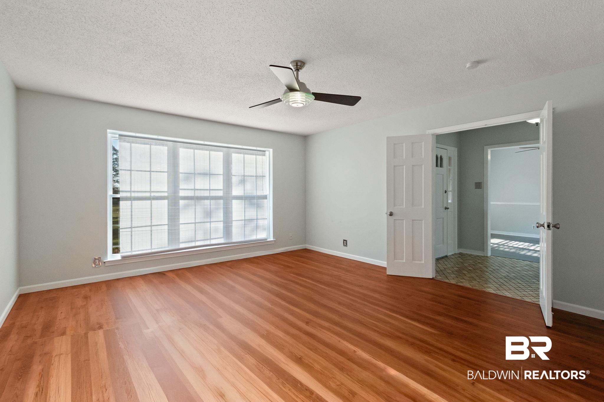 3864 Leroy Stevens Road Mobile, AL 36619 - Photo 13 of 33 Empty room featuring light wood-style flooring, a textured ceiling, and ceiling fan