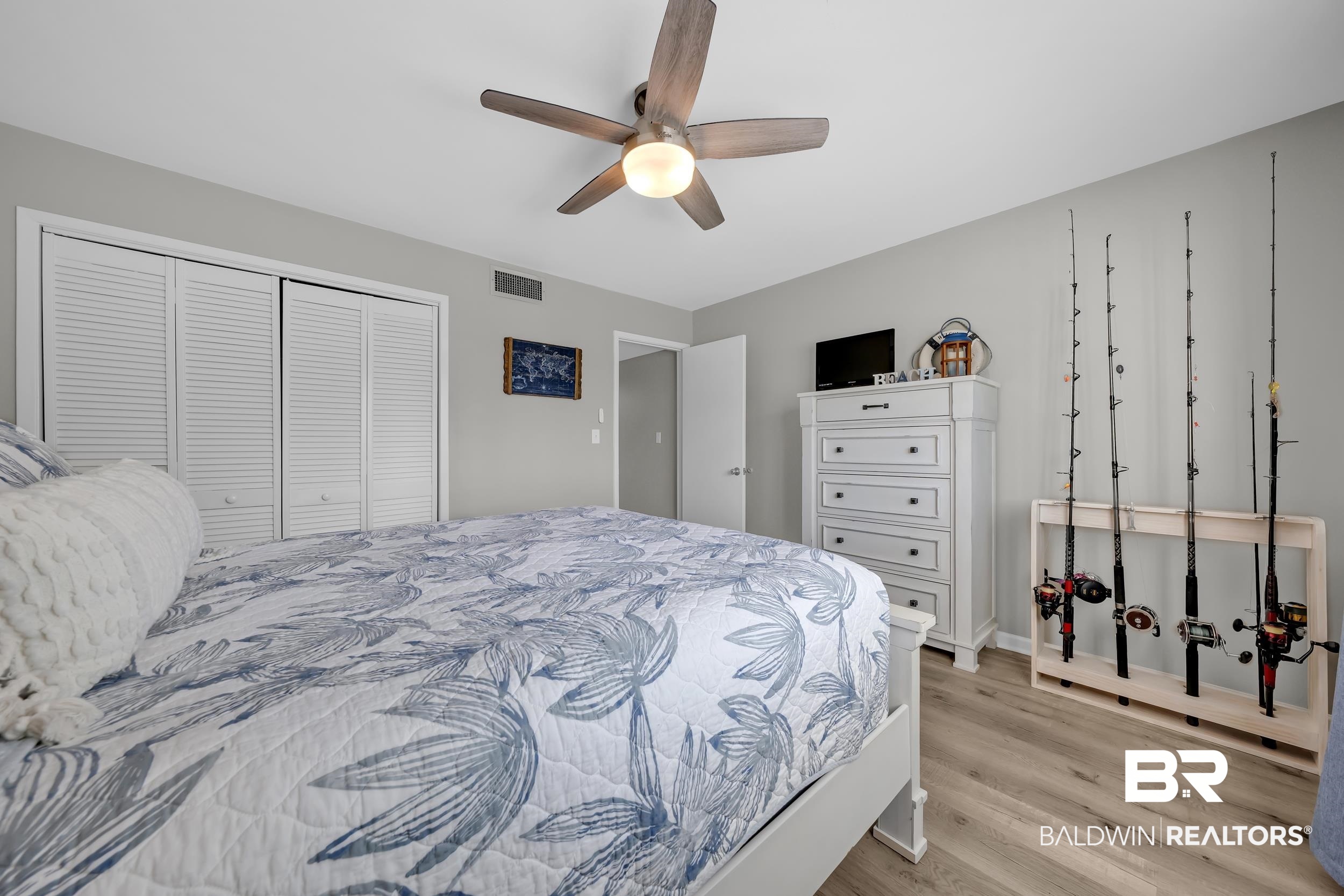 14100 River Road, Unit 211 Pensacola, FL 32507 - Photo 31 of 56 Bedroom featuring a ceiling fan with integrated lighting, two bi-fold louvered closet doors, and wood-finish flooring