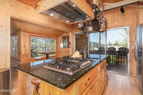 a kitchen with stainless steel appliances granite countertop a sink a stove and a wooden floors