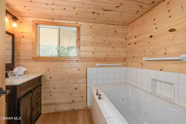 a bathroom with a bathtub sink and mirror
