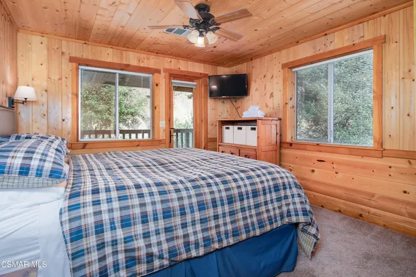 a bedroom with a bed next to a window with outer view
