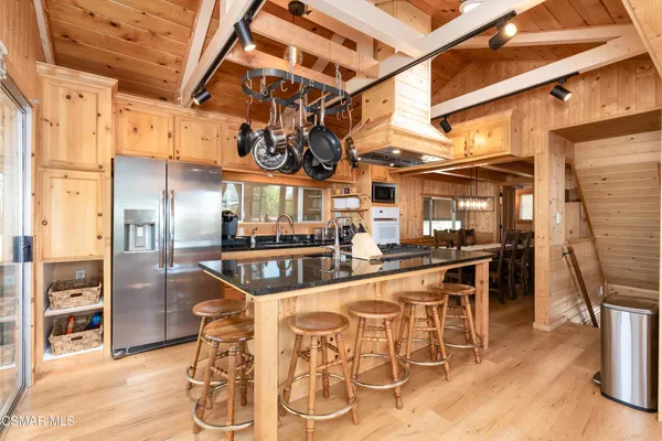 a kitchen with stainless steel appliances kitchen island granite countertop a table and chairs in it