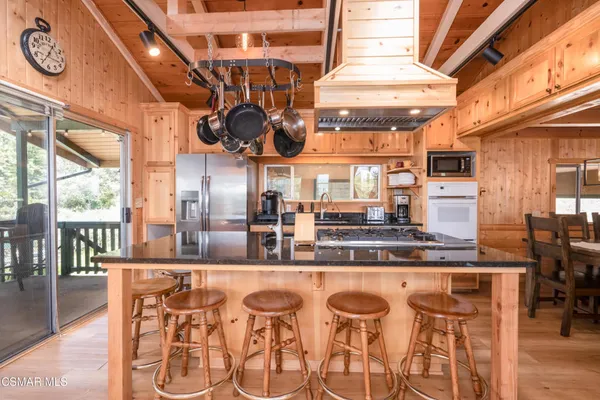 an open kitchen with stainless steel appliances granite countertop a stove and cabinets