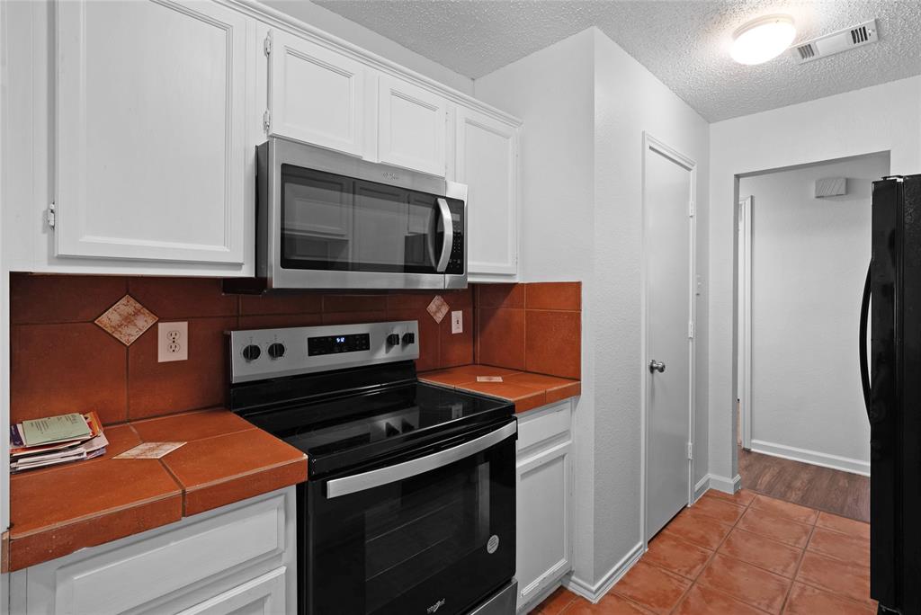 2910 Chisholm Trail Corinth, TX 76210 - Photo 13 of 30 a kitchen with stainless steel appliances granite countertop a stove microwave and refrigerator