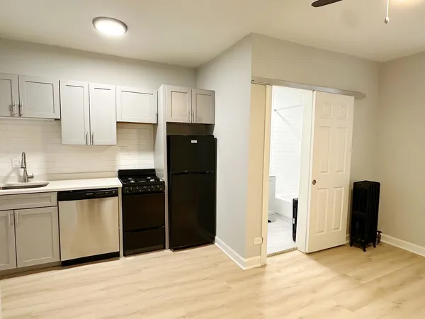 a kitchen with granite countertop a refrigerator and a stove top oven