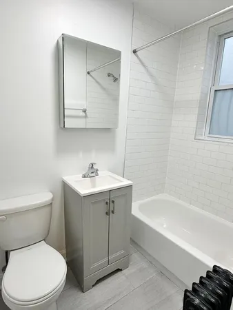 a white toilet sitting next to a bath tub