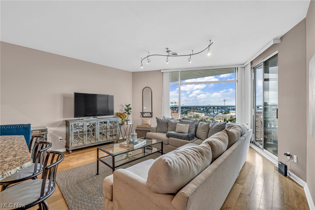 1237 Washington Avenue, Unit 1110 Cleveland, OH 44113 - Photo 4 of 28 Hardwood floored living room with floor to ceiling windows and track lighting