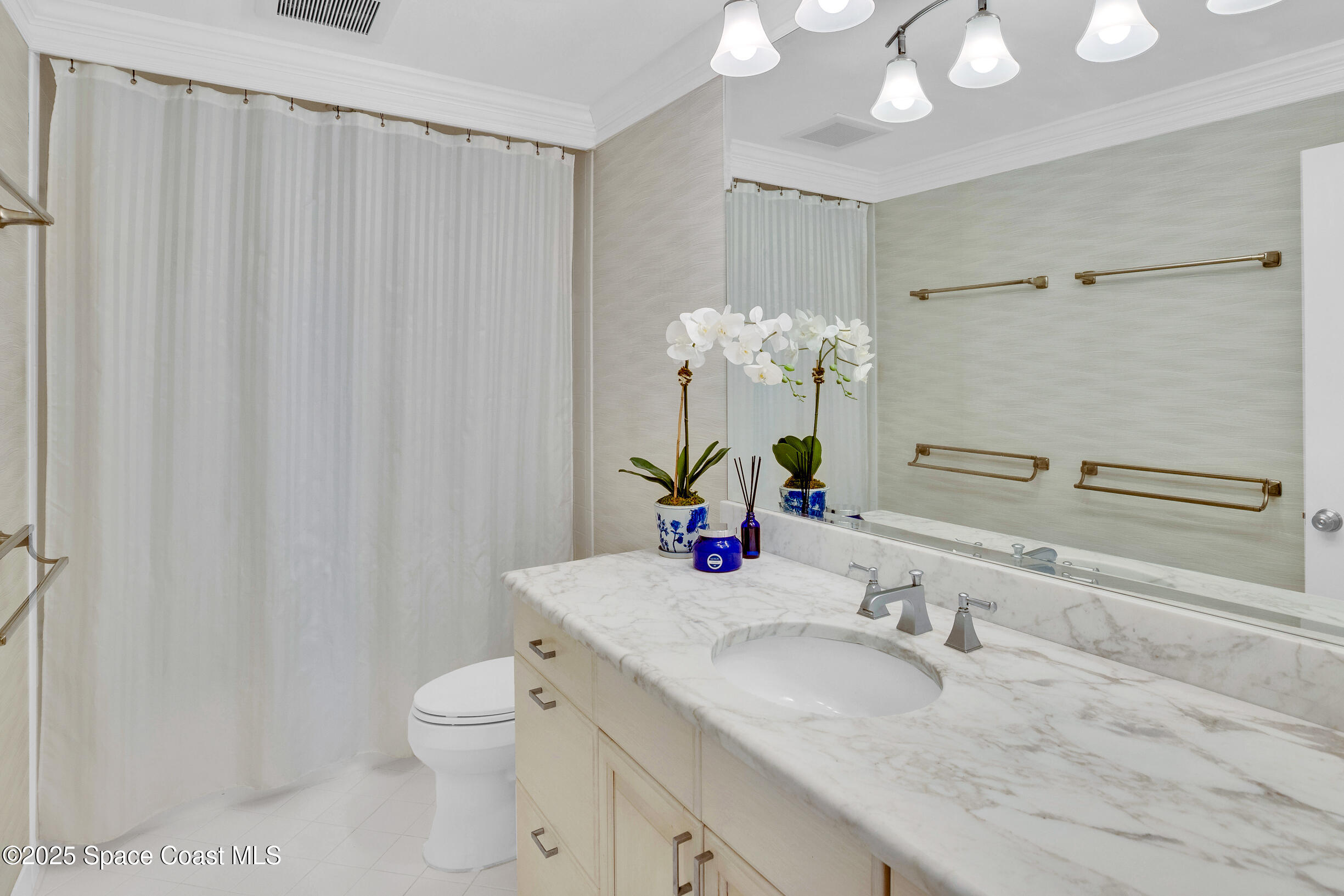 1903 Bay Road, Unit 205 Vero Beach, FL 32963 - Photo 36 of 53 a bathroom with a granite countertop sink a toilet and a mirror