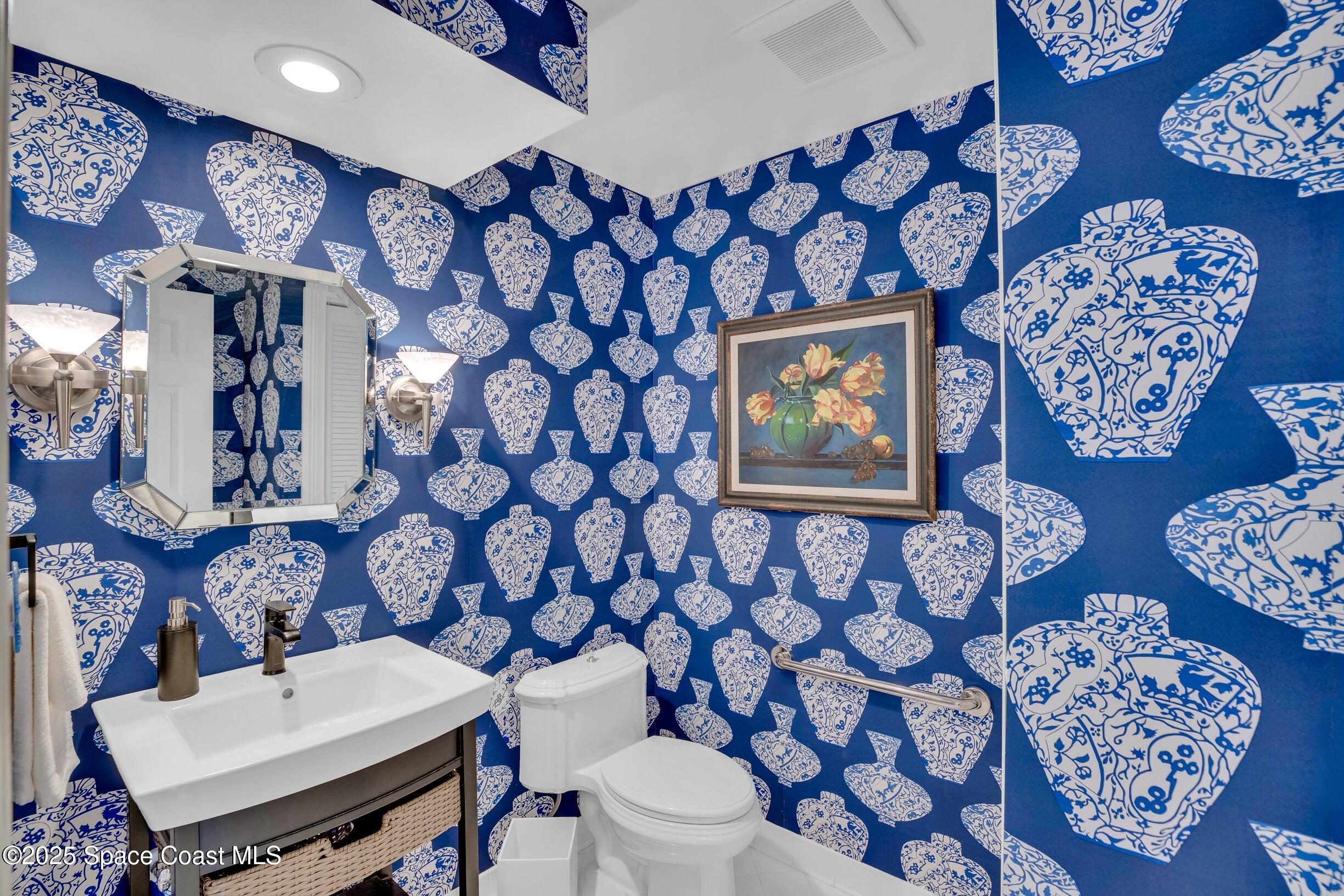 1903 Bay Road, Unit 205 Vero Beach, FL 32963 - Photo 38 of 53 a bathroom with a toilet sink and mirror