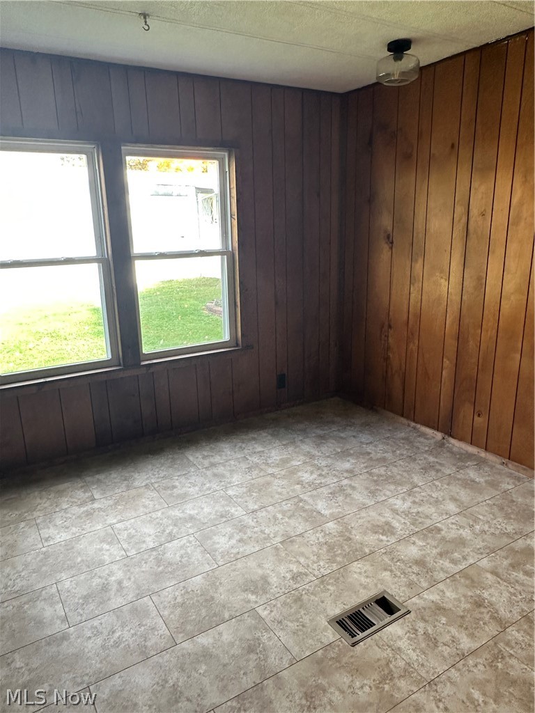7443 Spillway Road Lisbon, OH 44432 - Photo 13 of 19 Tiled empty room with wooden walls