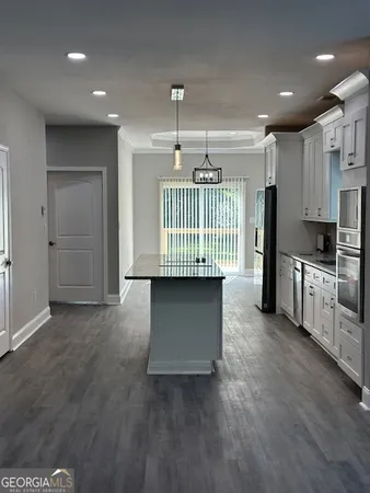 a view of kitchen with a sink cabinets and window
