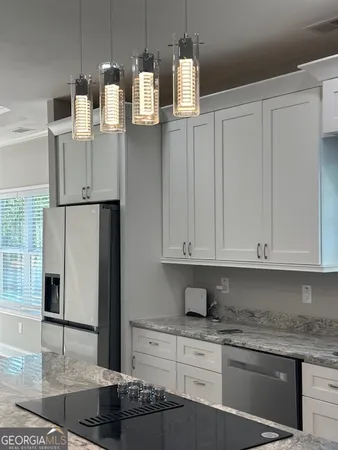 a kitchen with stainless steel appliances granite countertop a refrigerator and stove