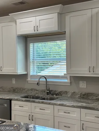 a kitchen with granite countertop cabinets and window