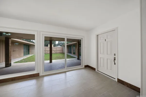 an empty room with floor to ceiling window and an entryway