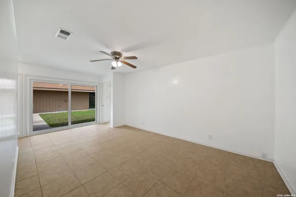 an empty room with a ceiling fan and a fireplace