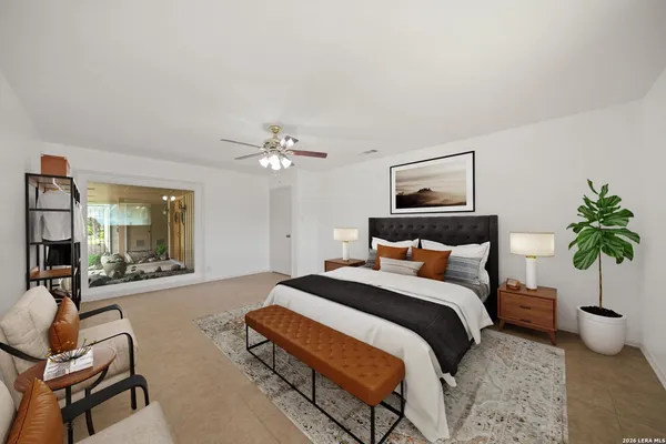 a bedroom with a bed a couch and potted plant