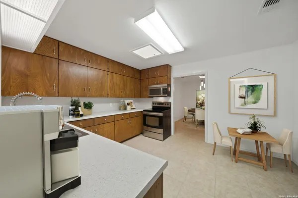 a kitchen that has a sink a stove and chairs