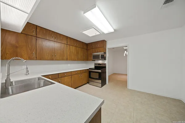 a kitchen with stainless steel appliances granite countertop a sink and a refrigerator