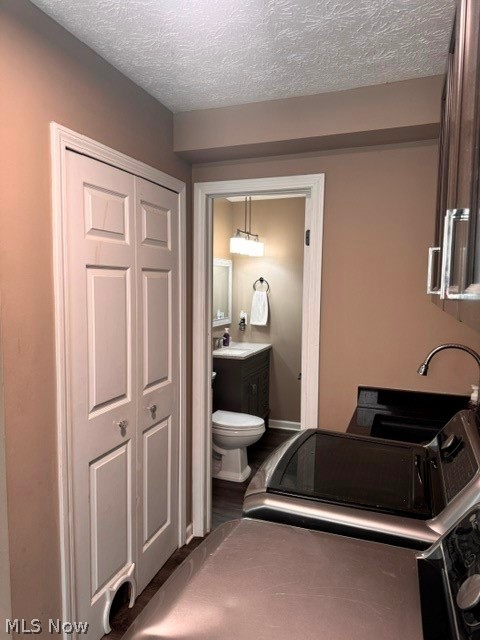 2760 Haines Road Madison, OH 44057 - Photo 32 of 33 Laundry area featuring dark wood-finish cabinetry and a built-in sink