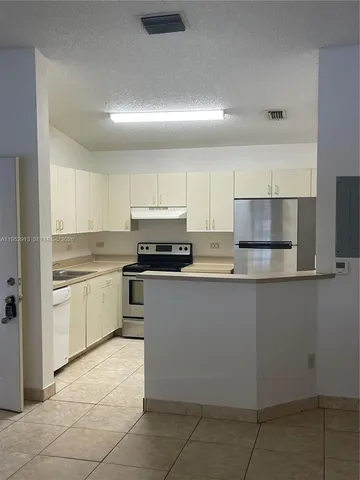 a kitchen with cabinets a sink and white appliances