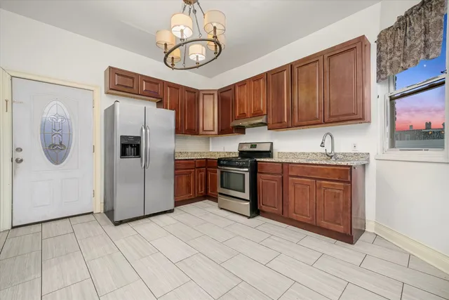 a kitchen with stainless steel appliances granite countertop a refrigerator a sink a stove and a microwave oven