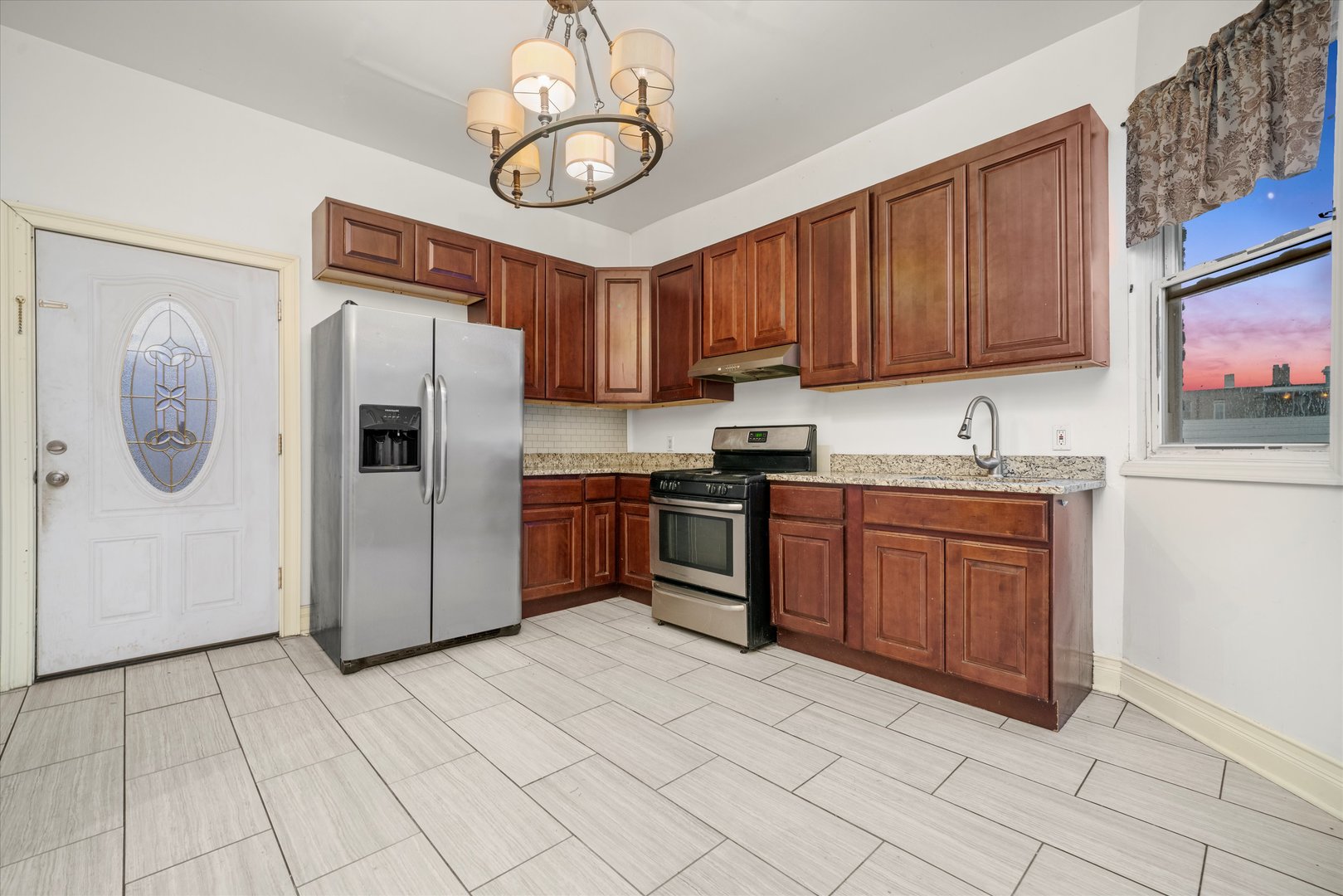 2128 West Cermak Road Chicago, IL 60608 - Photo 11 of 16 a kitchen with stainless steel appliances granite countertop a refrigerator a sink a stove and a microwave oven