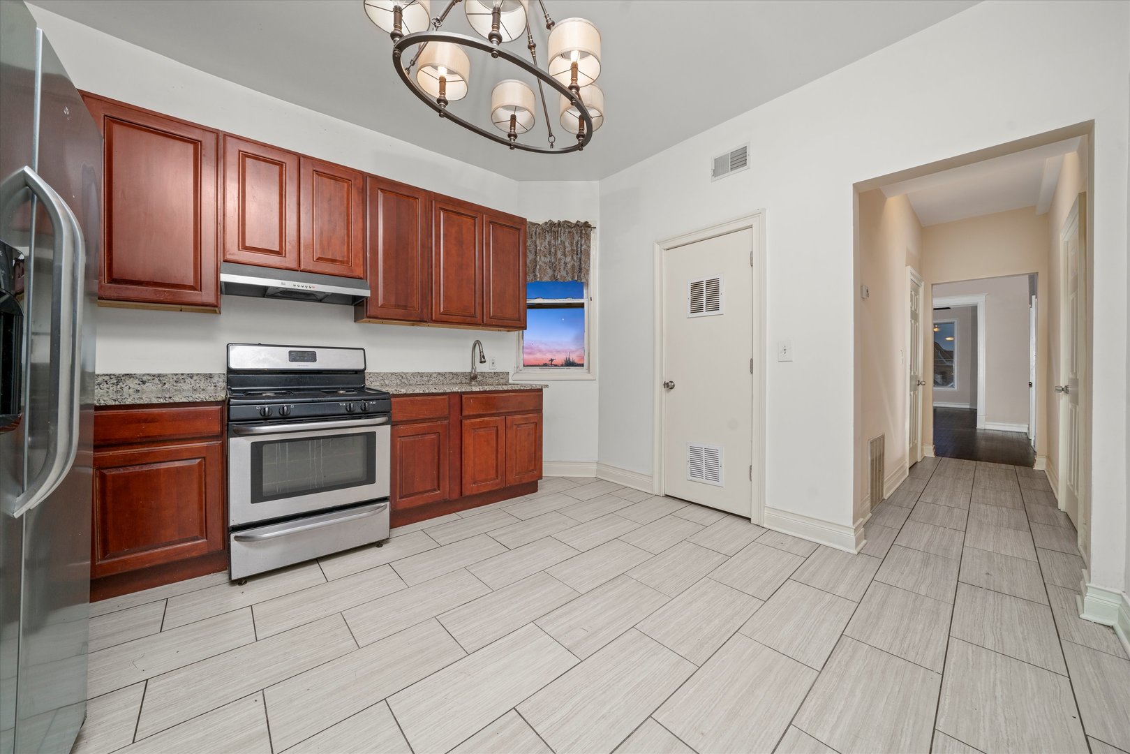 2128 West Cermak Road Chicago, IL 60608 - Photo 12 of 16 a kitchen with stainless steel appliances granite countertop a stove top oven a sink and cabinets