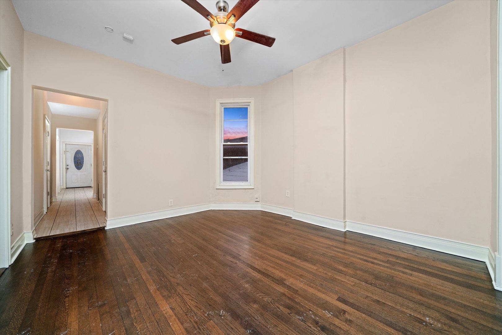 2128 West Cermak Road Chicago, IL 60608 - Photo 7 of 16 an empty room with wooden floor chandelier fan and windows