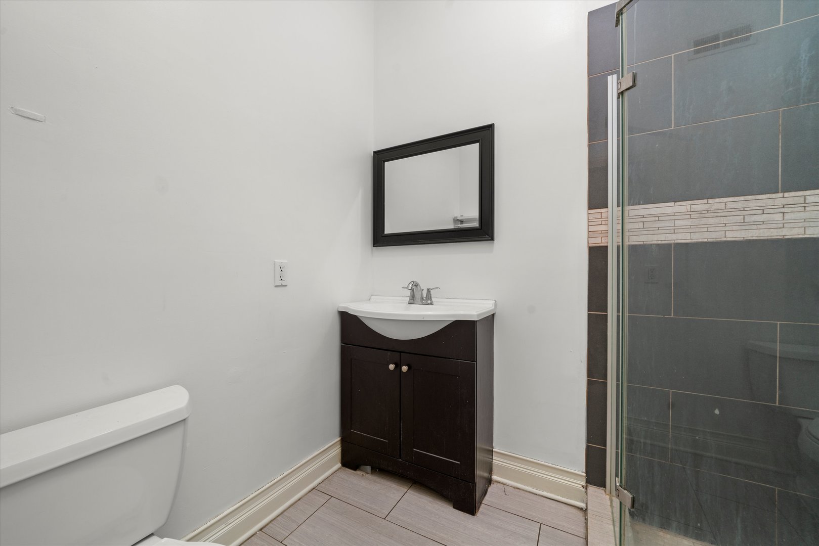 2128 West Cermak Road Chicago, IL 60608 - Photo 10 of 16 a bathroom with a sink a toilet and a mirror