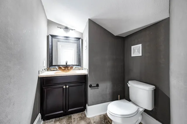 a bathroom with a toilet a sink and mirror