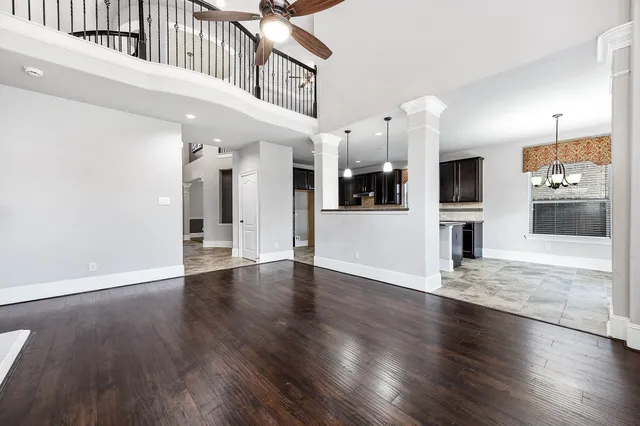 a view of a hallway with wooden floor and a kitchen