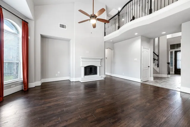 a view of an empty room window and wooden floor