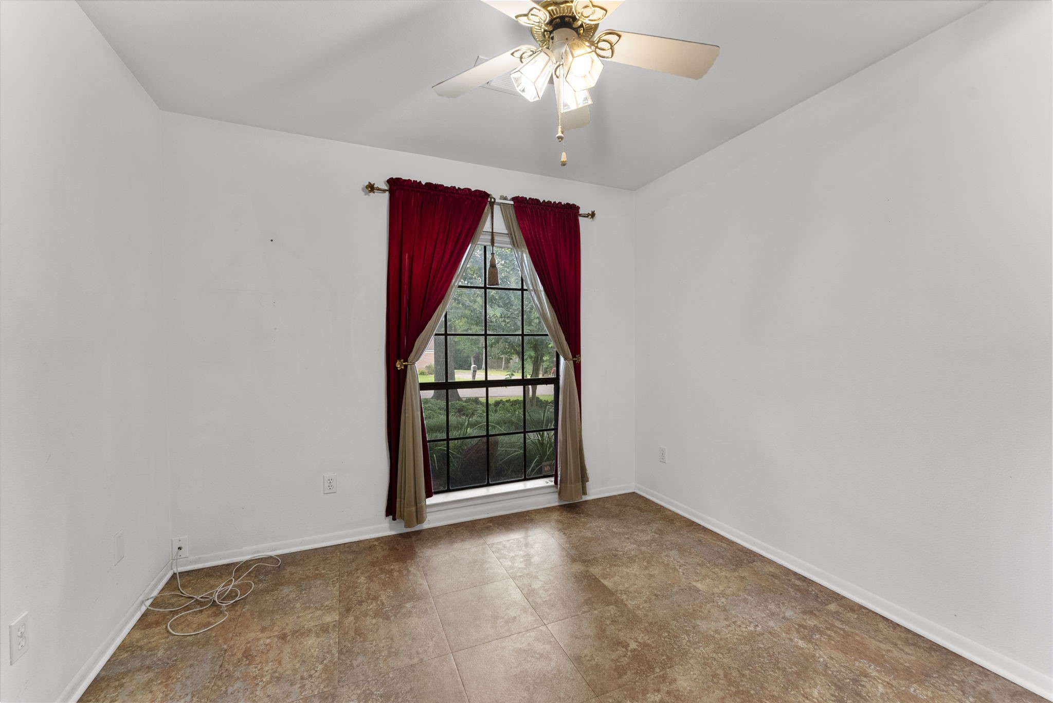 202 Sunset Boulevard Conroe, TX 77303 - Photo 26 of 50 This inviting guest bedroom features a large window with elegant red curtains, allowing natural light to enhance its cozy atmosphere and warm, laminate flooring, perfect for a welcoming retreat.