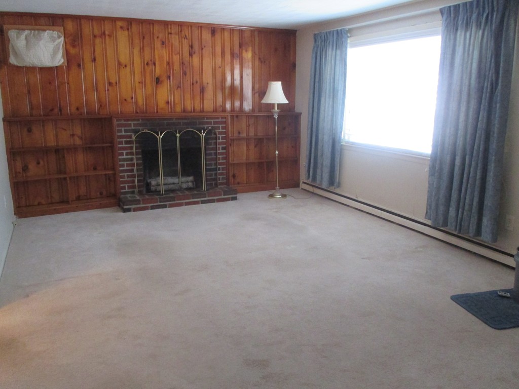 12 Locke Road Billerica, MA 01821 - Photo 4 of 16 a view of an empty room with a fireplace and a window