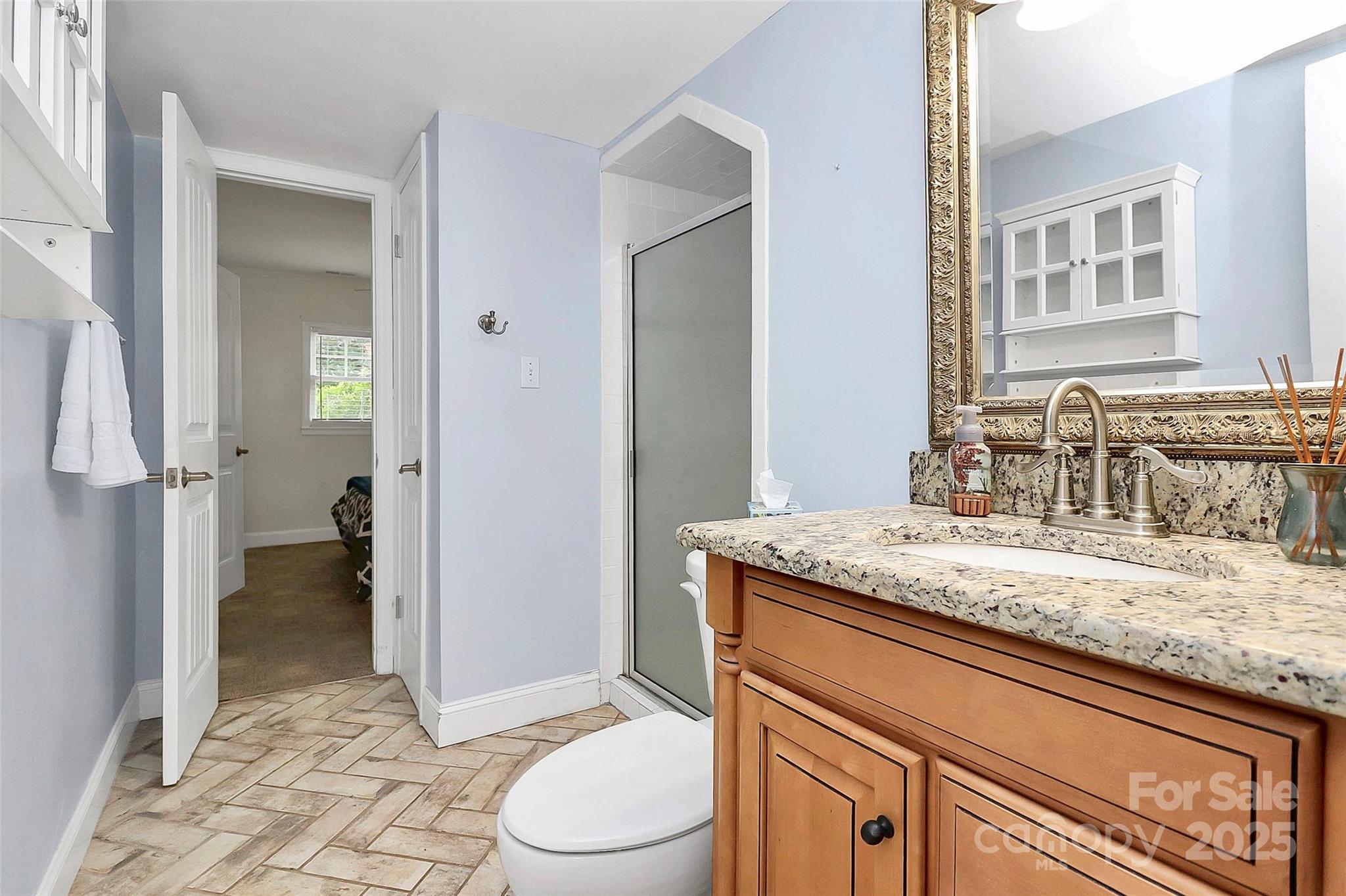6500 Old Providence Road Charlotte, NC 28226 - Photo 30 of 40 a bathroom with a granite countertop sink a toilet and shower