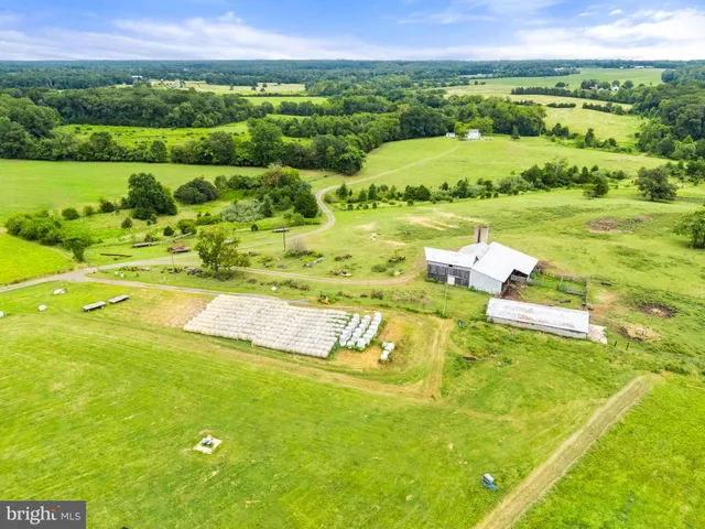 a bedroom with a bed and dresser with wooden floor
