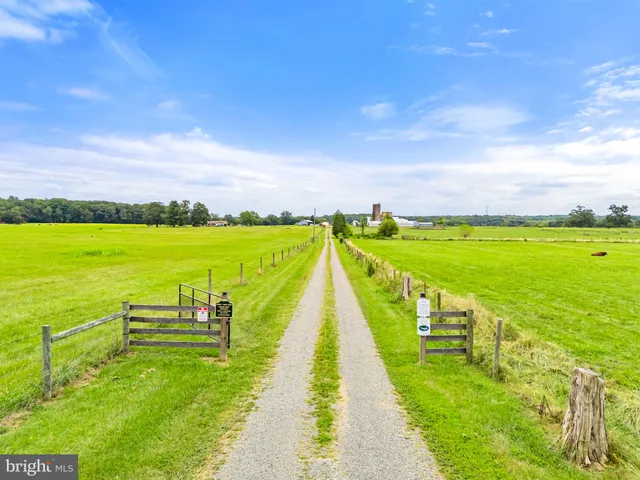 a view of a swimming pool with lawn chairs and a big yard